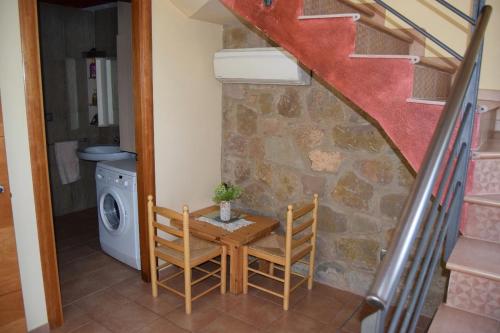 a room with a table and two chairs and a staircase at Casa con vistas al lago y con piscina - Casó Nou in La Baronia de Rialb