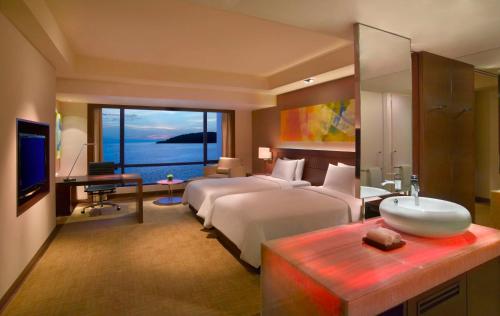 a bedroom with a bed and a sink and a television at Hyatt Regency Kinabalu in Kota Kinabalu