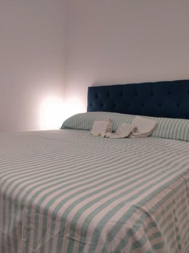 a bed with a blue headboard and two pink pillows at Setta Apartment in Lido di Ostia