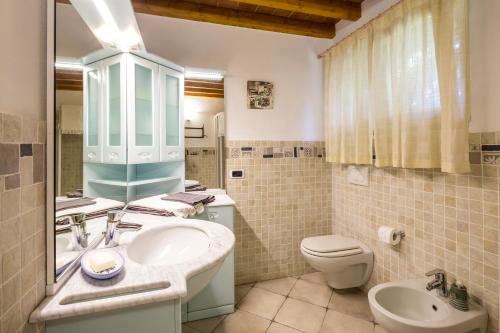 a bathroom with a sink and a toilet and a mirror at Borgo dell'Uccellaia - Turchese - Giada in Marciana Marina