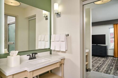 a bathroom with a sink and a large mirror at Homewood Suites by Hilton Anchorage in Anchorage