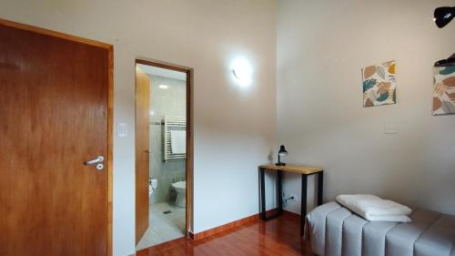Habitación con cama, espejo y puerta en MERMOZ en El Chaltén