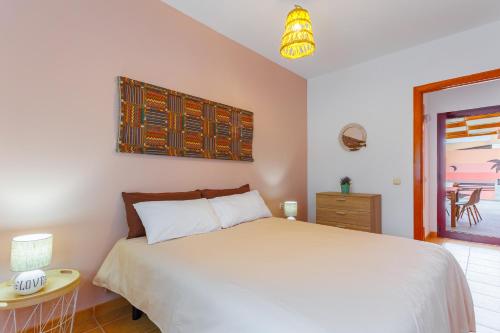 a bedroom with a white bed and a view of the ocean at Villa Roby Corralejo in La Oliva