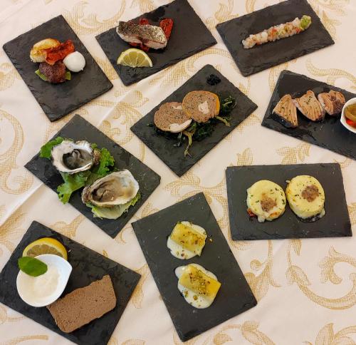 a table topped with different types of food on plates at Hotel Acapulco in Forte dei Marmi