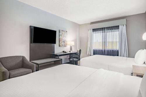 Habitación de hotel con 2 camas y escritorio en La Quinta by Wyndham Evansville, en Evansville