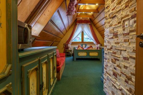 a attic room with a bed in a room at Leśny Dworek Zakopane in Zakopane