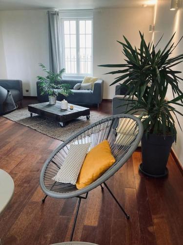 a living room with a chair with a yellow pillow at 38BIS Location nuit / week-end / vacances in Chaignay