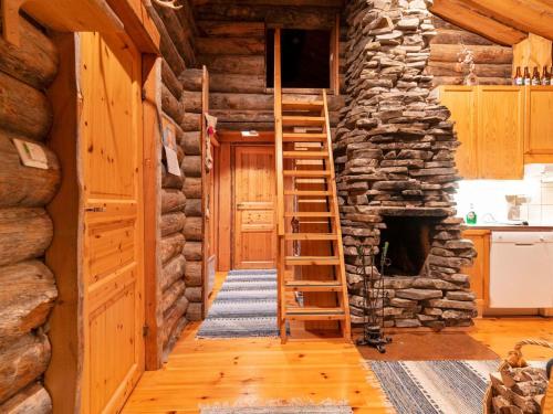 a staircase in a log cabin with a stone fireplace at Holiday Home Lomaylläs d59 -palovaarankaarre 13 a by Interhome in Ylläsjärvi