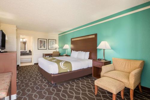 Habitación de hotel con cama y silla en Quality Inn Tulsa Central, en Tulsa