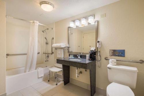 a bathroom with a sink and a toilet and a tub at Quality Inn Tulsa Central in Tulsa