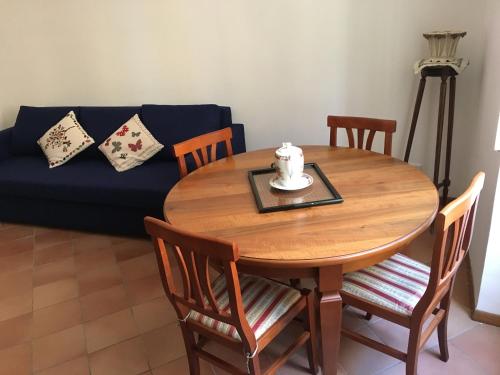 un tavolo in legno con sedie e un divano blu di Sweety Rome House a Roma