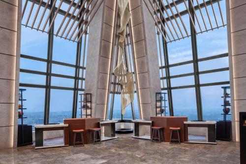a room with tables and chairs in a building with large windows at JW Marriott Hotel Xi'an in Xi'an