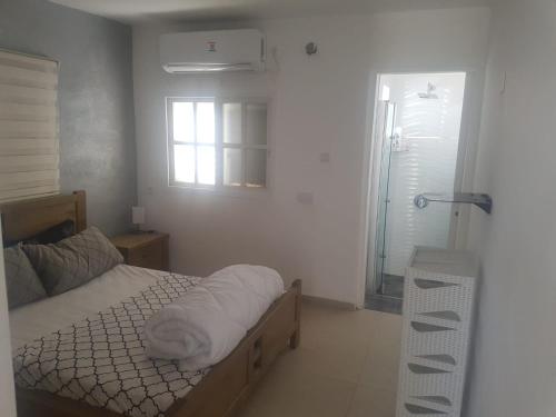 a bedroom with a bed and a window and a shower at arad rooms & apartments חדרי אירוח ערד in Arad