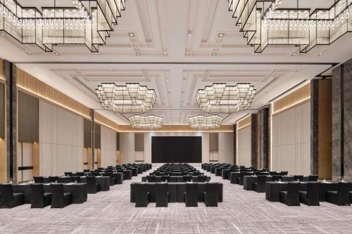 a large room with black chairs and a projection screen at JW Marriott Hotel Xi'an in Xi'an