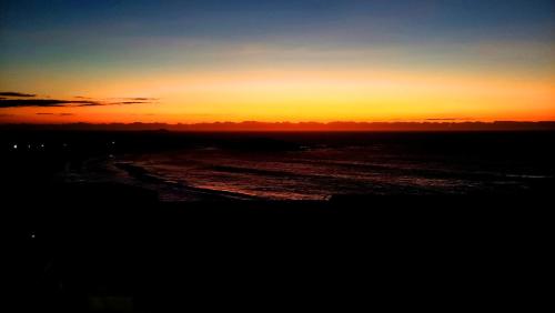 a sunset over a body of water with at Casa na praia de Setiba com panorama fantástico in Guarapari