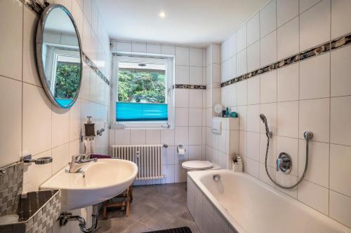 a bathroom with a sink and a tub and a toilet at Ferienwohnung Panorama in Neusatzeck