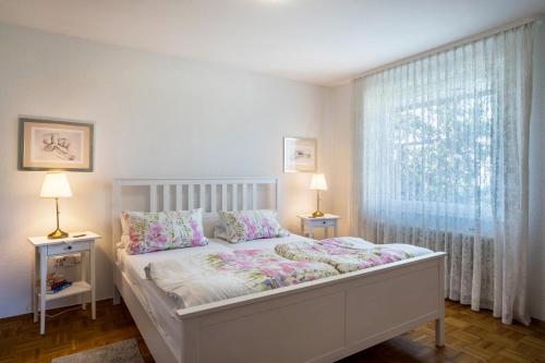 ein Schlafzimmer mit einem Bett mit zwei Lampen und einem Fenster in der Unterkunft Ferienwohnung Panorama in Neusatzeck