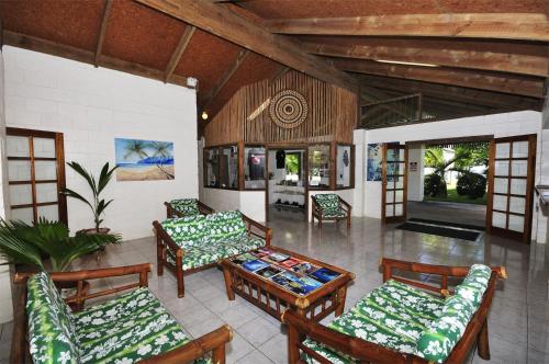 a living room with couches and a table and chairs at Kosrae Nautilus Resort in Yepan