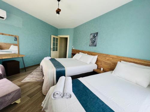 2 letti in una camera d'albergo con pareti blu di aria plus ev-otel a Çiftlikköy