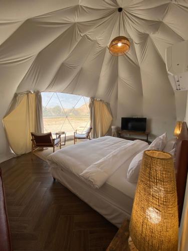 a bedroom with a bed in a tent at منتجع جلامبنغ - Glamping Resort in Al Fawwāz