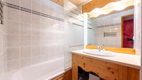 a bathroom with a sink and a tub and a mirror at La Turra 410 - Appt pres des pistes 6 pers in Modane