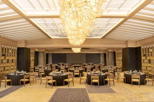 a ballroom with tables and chairs and a chandelier at JW Marriott Jeju Resort & Spa in Seogwipo