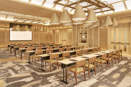 a large room with tables and chairs and a screen at JW Marriott Jeju Resort & Spa in Seogwipo