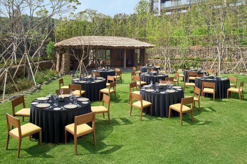 a set up for a wedding reception in a garden with tables and chairs at JW Marriott Jeju Resort & Spa in Seogwipo