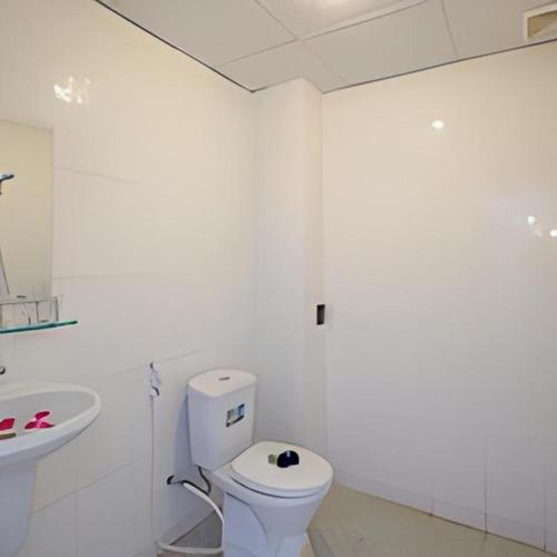 a white bathroom with a toilet and a sink at Cua Dai Beach Homestay in Hoi An