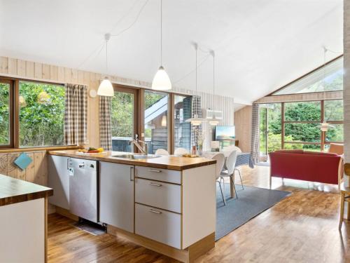 een keuken met witte kasten en een eetkamer bij Holiday Home Wilgrib - 400m from the sea in Sealand by Interhome in Højby