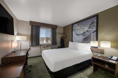 una camera d'albergo con un grande letto e una scrivania di SureStay Hotel by Best Western Williams - Grand Canyon a Williams