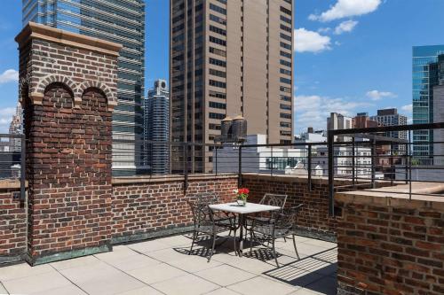 un patio con tavolo e sedie all'ultimo piano di Hotel 57 by LuxUrban a New York