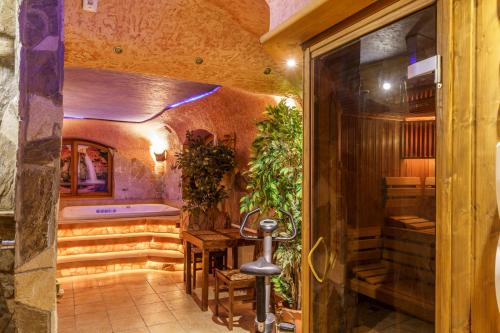 a spa room with a tub and a table with plants at Leśny Dworek Zakopane in Zakopane
