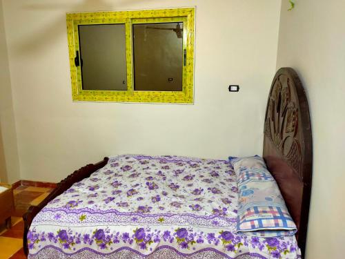 Bett in einem Zimmer mit Spiegel und Fenster in der Unterkunft Your place in Al-Fayyūm