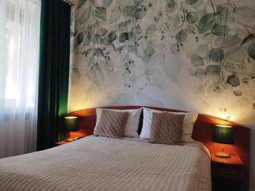 sypialnia z łóżkiem z kwiatową ścianą w obiekcie Złoty Lin w Serocku