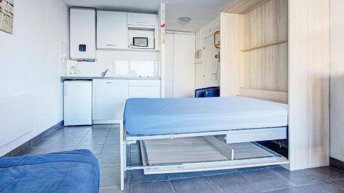 Cette petite chambre comprend un lit et une cuisine. dans l'établissement La Croisette 12 - Studio lumineux 3 pers, au Cap d'Agde