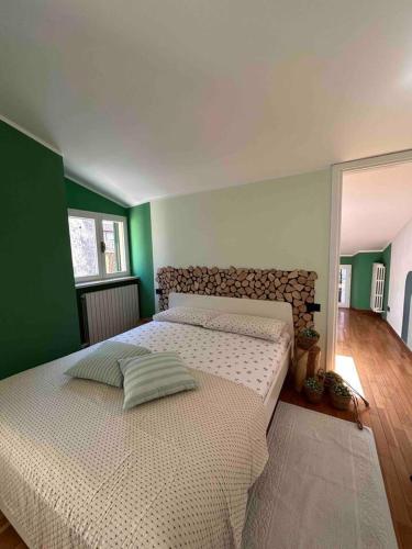 a large bed in a bedroom with green walls at the green nest in Olginate