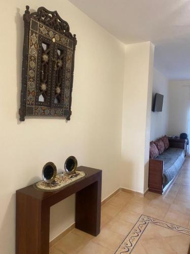 um quarto com uma mesa com duas taças na parede em Appartement à résidence Ap8 , marina , saidia em Berkane
