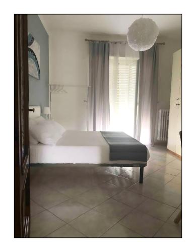 a bedroom with a white bed and a large window at Lingotto Side House - Affitti Brevi in Turin