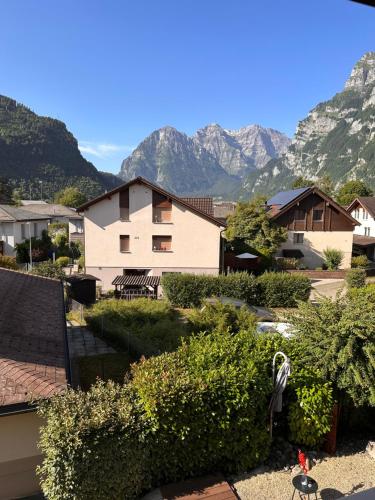 a view of a house with mountains in the background at Zimmer mit eigenem Badezimmer in Näfels