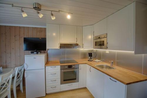 a kitchen with white cabinets and a wooden counter top at Kvetos naturopplevelser in Beitostøl