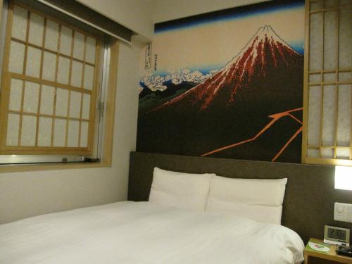 a bedroom with a large painting of a mountain at Dormy Inn Akihabara in Tokyo
