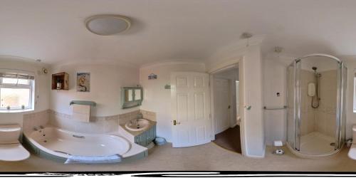 a bathroom with a tub and a shower and a toilet at Endeavour Cottage - A Wonderful Whitby Holiday in Whitby