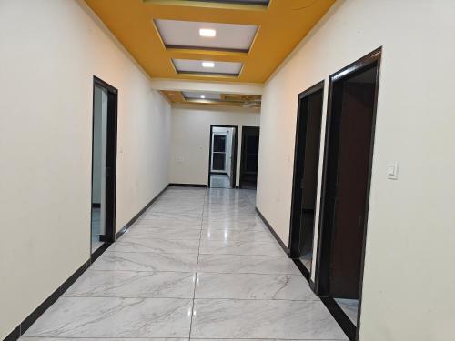 a corridor of an office building with doors and a tile floor at Comfort Cove Apartments in Mysore
