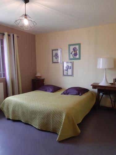 - une chambre avec un grand lit et des oreillers violets dans l'établissement L'Orée du Golf 2étoiles Proche Bourgoin & l'Isle d'Abeau, à Four