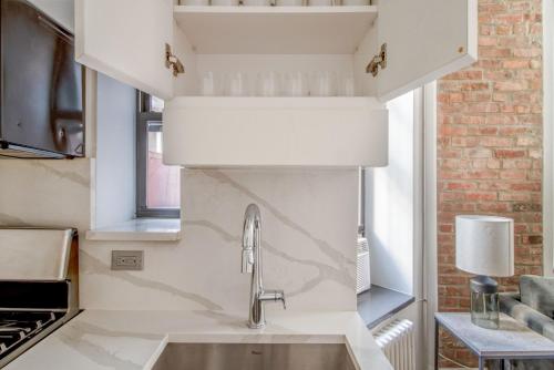 a kitchen with white cabinets and a sink at Nolita 1br w wd nr shopping groceries NYC-1220 in New York