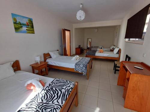 a hotel room with three beds and a desk at Villa Ramos in Albufeira