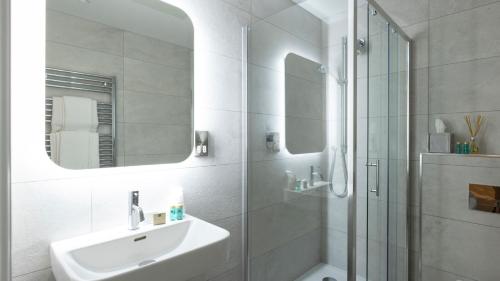 a white bathroom with a sink and a shower at Wynn's Hotel in Dublin