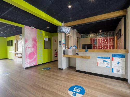 a waiting area in a store with green walls at Ibis Budget Sarrebourg Buhl in Sarrebourg