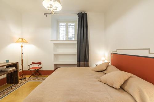 Un dormitorio con una cama y un escritorio y una ventana. en Popolo Charming Apartment, en Roma
